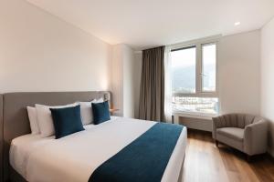 pokój hotelowy z dużym łóżkiem i krzesłem w obiekcie VOU Suites by Avia Suites w mieście Bogota