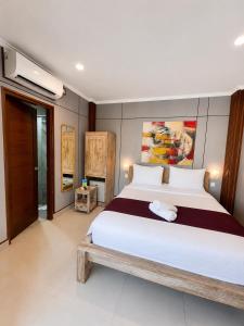 a bedroom with a large white bed in a room at Dana Homestay in Canggu