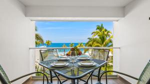 a table on a balcony with a view of the ocean at Gorgeous 1BR Condo with Pools & Sea Views in Puerto Vallarta