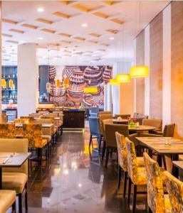 a restaurant with tables and chairs and a fireplace at Flat Executivo GRU Airport in Guarulhos