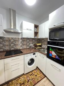 a kitchen with white cabinets and a washer and dryer at Marina Escape, 2BD, Pool and Beach in Hammam Sousse