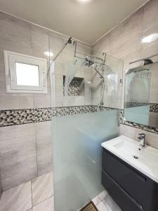 a bathroom with a glass shower and a sink at Marina Escape, 2BD, Pool and Beach in Hammam Sousse