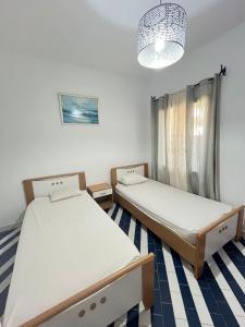 a room with two beds and a chandelier at Marina Escape, 2BD, Pool and Beach in Hammam Sousse