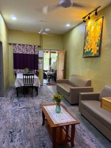 a living room with a couch and a table at Sri impiana in Pantai Cenang