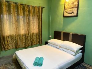 a bed with two pairs of blue shoes on it at Sri impiana in Pantai Cenang