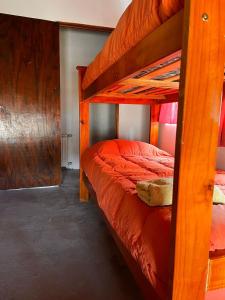 a bedroom with two bunk beds with red sheets at Refugio Pehuenche in Los Molles