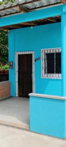a blue building with a gate and a door at Casa em salinas in Salinópolis