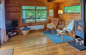 a living room with a fireplace in a log cabin at Cozy Home In Ebeltoft With Wifi in Ebeltoft