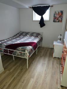 Ein Schlafzimmer mit einem Bett in einem Zimmer mit Holzboden in der Unterkunft Chambre privée dans logement partagé in Saint-Nazaire