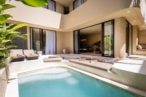 a living room with a swimming pool and a house at SISI Wellness Villas in Bingin Beach