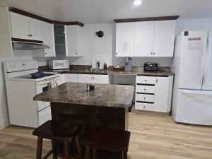 eine Küche mit weißen Schränken und einer Marmorarbeitsplatte in der Unterkunft Chambre privée dans logement partagé in Saint-Nazaire