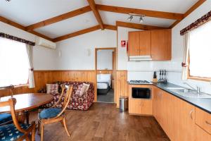 a kitchen and living room with a table and a couch at Riverside Cabin Park in Shepparton