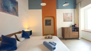 a bedroom with a large white bed with blue pillows at Diso apartments in Naples