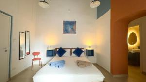 a bedroom with a large white bed with blue pillows at Diso apartments in Naples