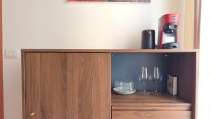 a wooden cabinet with two wine glasses on it at Diso apartments in Naples +95 photos