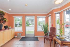 a living room with orange walls and windows at Sweet Breeze Inn Grants Pass in Grants Pass