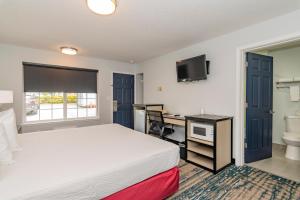 a bedroom with a bed and a desk and a sink at Sweet Breeze Inn Grants Pass in Grants Pass