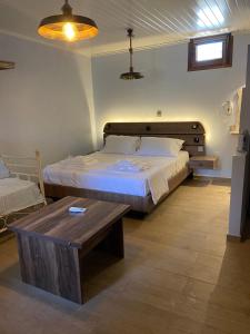 a bedroom with a large bed and a wooden table at Περιβόλι του Οδυσσέα in Volissos