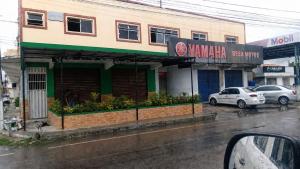 a building on a street with cars parked in front at Pousada Quixadá Central in Quixadá