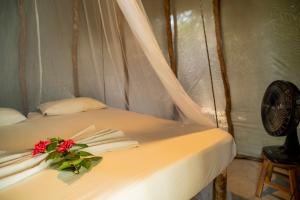 a white bed with a flower on top of it at Treehouse Kitecamp Jericoacoara in Jericoacoara +23 photos