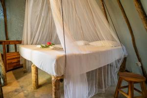 a bed with a canopy in a room at Treehouse Kitecamp Jericoacoara in Jericoacoara
