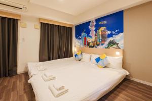 a bedroom with a large white bed with a painting on the wall at MAIDO - Doyanen Hotels in Osaka