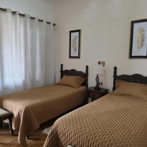 a bedroom with two beds and a window at Hotel Posada San Rafael in Pátzcuaro