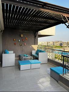eine Terrasse mit Sofas und Tischen an einem Gebäude in der Unterkunft Lagoon Blumar Hotel Chalet in Ain Suchna