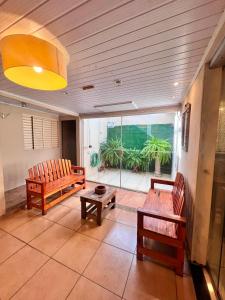 a living room with two benches and a table at Casa Aconchego! in Uberaba
