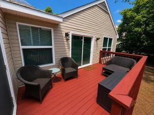 a wooden deck with chairs and a table on a house at The Williamsburg Haven in Williamsburg
