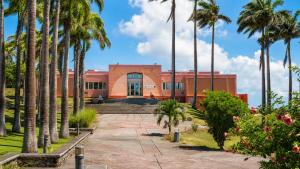a building with palm trees in front of it at Villa Arc-en-ciel in Le Moule