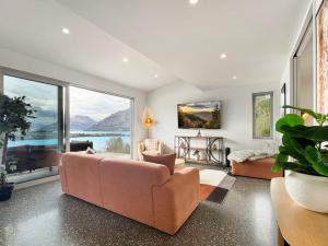 a living room with a couch and a large window at Epic Views and Deck | Spacious Queenstown Home in Queenstown