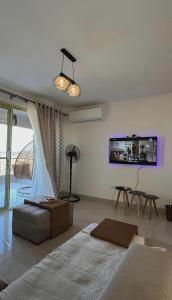 ein Wohnzimmer mit Bett und Fernseher in der Unterkunft Lagoon Blumar Hotel Chalet in Ain Suchna