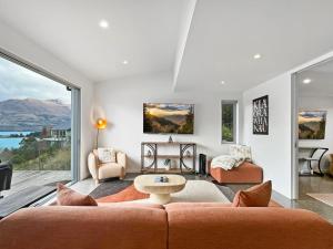 a living room with a couch and a large window at Epic Views and Deck | Spacious Queenstown Home in Queenstown