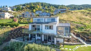an aerial view of a house on a hill at Epic Views and Deck | Spacious Queenstown Home in Queenstown +27 photos