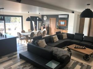 a living room with a black couch and a table at Villa Champlan in Champlan