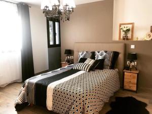 a bedroom with a large bed and a chandelier at Villa Champlan in Champlan
