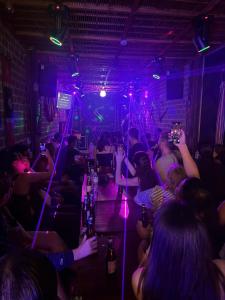a group of people sitting at a bar in a club at Savor Hostel-Motorbike Rental-Tour in Làng Lap