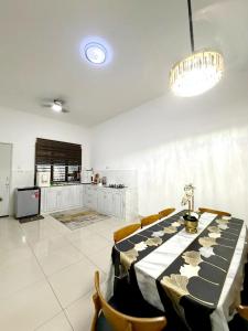 a dining room with a long table and chairs at Mishary Homestay in Malacca