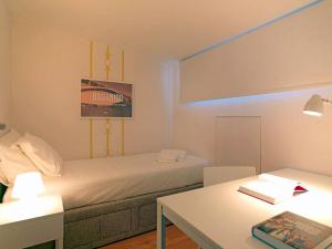 a room with a bed and a desk and a table at Uporto House Villa in Porto