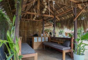a porch with a bench and a table and some plants at Kabilin Homestay in General Luna