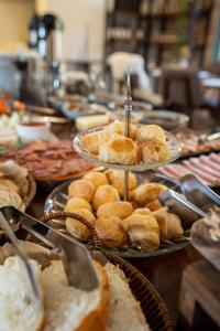 a table topped with plates of bread and pastries at Pousada Calza - Vale dos Vinhedos - Bento Gonçalves in Bento Gonçalves