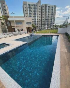 a swimming pool with blue water in front of a building at Lar Luar do Sertão in Aracaju