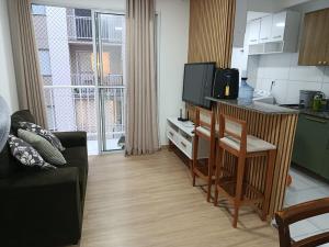 a living room with a table and a kitchen with a tv at Lar Luar do Sertão in Aracaju
