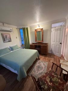 a bedroom with a bed and a desk and a mirror at Seaside Escape in Montego Bay