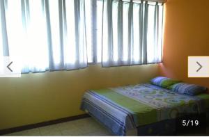 a bedroom with a bed in front of a window at Chellas fish in San Salvador