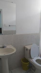 a bathroom with a sink and a toilet and a mirror at Chellas fish in San Salvador