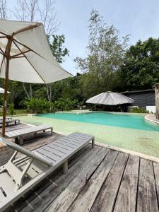 a pool with two lounge chairs and an umbrella at Akasha suites in Doradal +20 photos