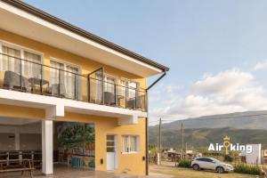 a yellow building with a car parked in front of it at Suites Amplias y Comfortables - Con Balcon, Parquizado, Asador y Pileta in Tafí del Valle