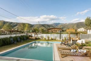 a swimming pool with chairs and mountains in the background at Suites Amplias y Comfortables - Con Balcon, Parquizado, Asador y Pileta in Tafí del Valle +34 photos